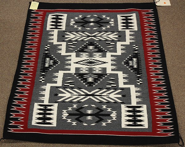 (lot of 2) Navajo weaving group: (lot of 2) Navajo weaving group, consisting of a Storm Pattern blanket by Jan Yazzie 45" x 48", and an all natural mat by Ruth Nelwood 16.5" x 18.5"