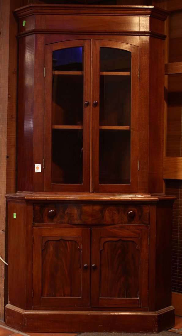 Diminutive step back corner cabinet: Diminutive step back corner cabinet, 19th century, executed in mahogany, having a molded cornice above two arched glazed doors, surmounting a serpentine drawer above two doors, 71"h x 38"w x 23"d