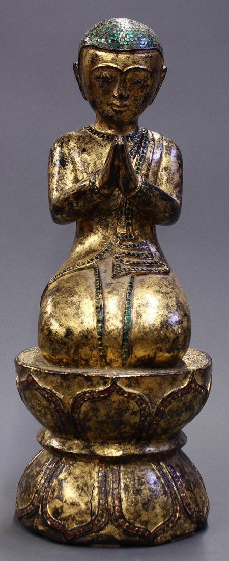 Burmese Gilt Wood Monk: Burmese gilt wood Buddhist figure, of a monk in a votive position, the head and hem line heightened with green mirrors, raised on a lotus pedestal, 21"h