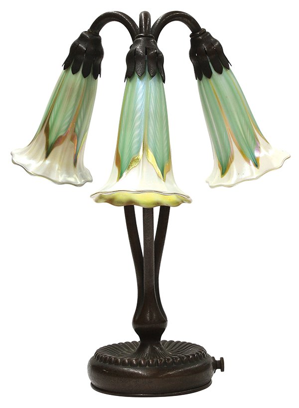 Tiffany Studios: Tiffany Studios, New York, three light lily lamp, having three stems banded together, each supporting a Quezal shade having pulled feather decoration of green and gilt leaves on an opalescent ground, 