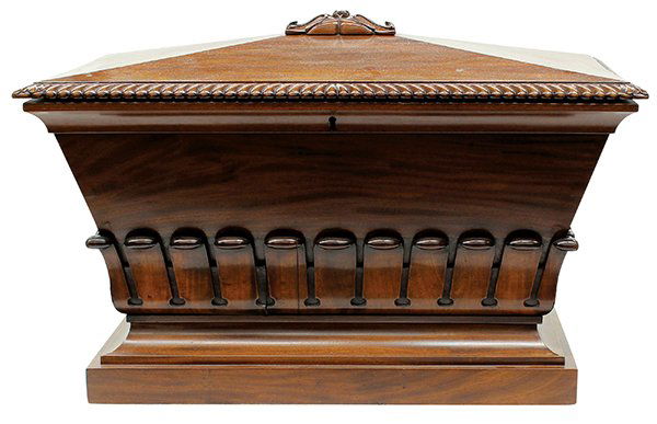 English Regency mahogany cellarette, circa 1810, having: English Regency mahogany cellarette, circa 1810, having a carved finial above the domed lid and a gadrooned border, opening to a partial tin lined interior, and rising on a molded base, 18"h x 32.5"w
