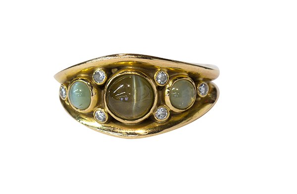 Crysoberyl cats eye diamond yellow gold ring: Crysoberyl cats eye, diamond and 14k yellow gold ring featuring three round cabochon cut crysoberly cat's eyes, one measuring approximately 5.5 x 3.25 mm, two measuring approximately 3.5 x 2.5 mm, acc