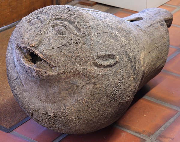 Indonesia, probably Sumatra, slit gong or drum with a: Indonesia, probably Sumatra, slit gong or drum with a face on its large front; tapers to back, hollowed interior for drum sound, signs of use and age, approximately 53''l x 19''d