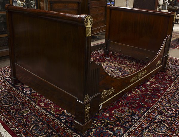 French Empire ormolu mounted lit d' alcove: French Empire ormolu mounted lit d' alcove, 19th century, the contoured pilasters with wreath and scroll decorated mounts flanking the highly figured rail centered with a rosette medallion and accente