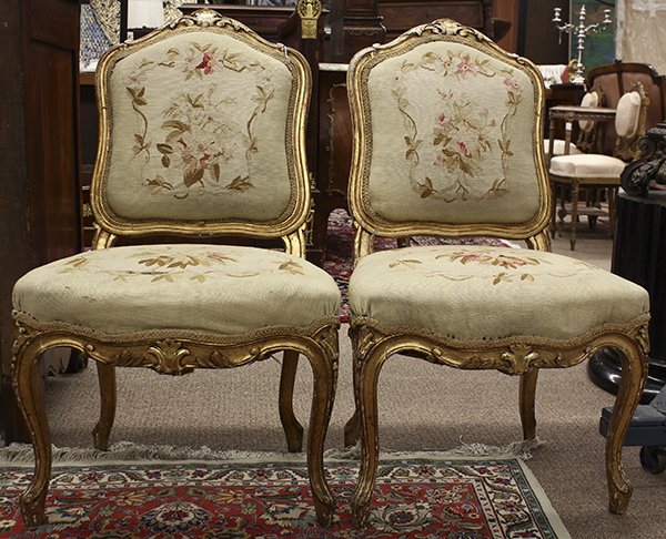 Pair of Louis XV style giltwood carved salon chairs: Pair of Louis XV style giltwood carved salon chairs, 19th century, the relief carved crest surmounting the aubusson show cover accenting the seat and back, and rising on floral carved cabriole legs, 3
