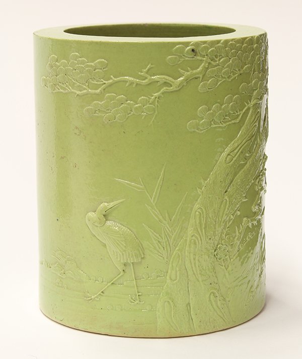 Chinese Green Glaze Brush Pot, Wang Bingrong Marked: Chinese green glazed porcelain brush pot, featuring a crane standing below pine and prunus branches in relief, the base marked 'Wang Bingrong zuo' (minor chips), 5.75"h x 4.6"w
