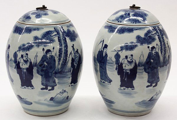 Two Chinese Blue and White Jars: Pair of Chinese underglaze blue porcelain jars, of olive form decorated with the Eight Daoist Immortals under a pine tree, the dome lid with a metal ring handle, the base with apocryphal Kangxi mark,1