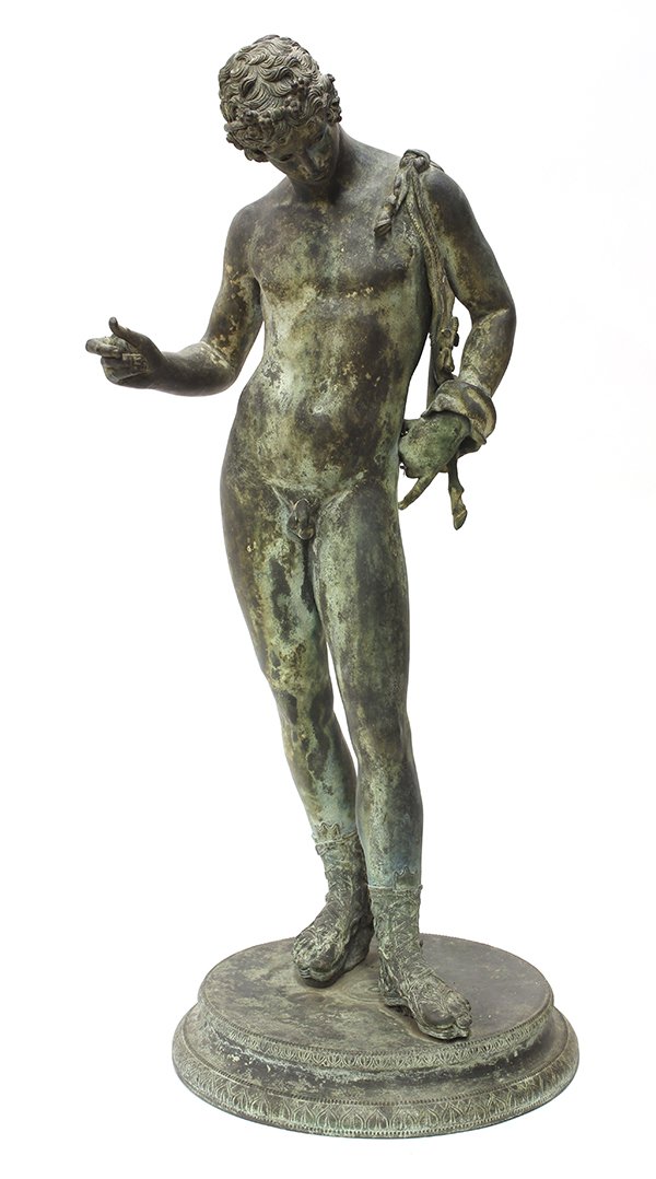 Classical style patinated bronze sculpture of a male: Classical style patinated bronze sculpture of a male, depicting a Greek wearing a wreath, cape, and intricately detailed sandals, the young man strikes a contrapposto pose looking down and to the side