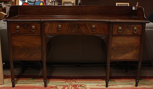 Federal sideboard: Federal mahogany sideboard, first quarter 19th century, the rectangular top having a gadrooned border, surmounting the three drawer case having gilt figural ring pulls, and rising on turned legs, 42.5