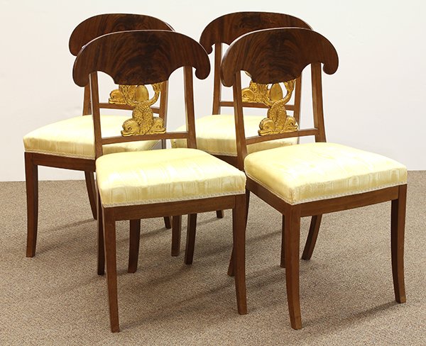 (lot of 4) Biedermeier dining chairs: (lot of 4) Biedermeier dining chairs, 19th century, the inswept mahogany crestrail above the gilt decorated figural splat depicting stylized dolphins, continuing the yellow upholstered seat, and risin