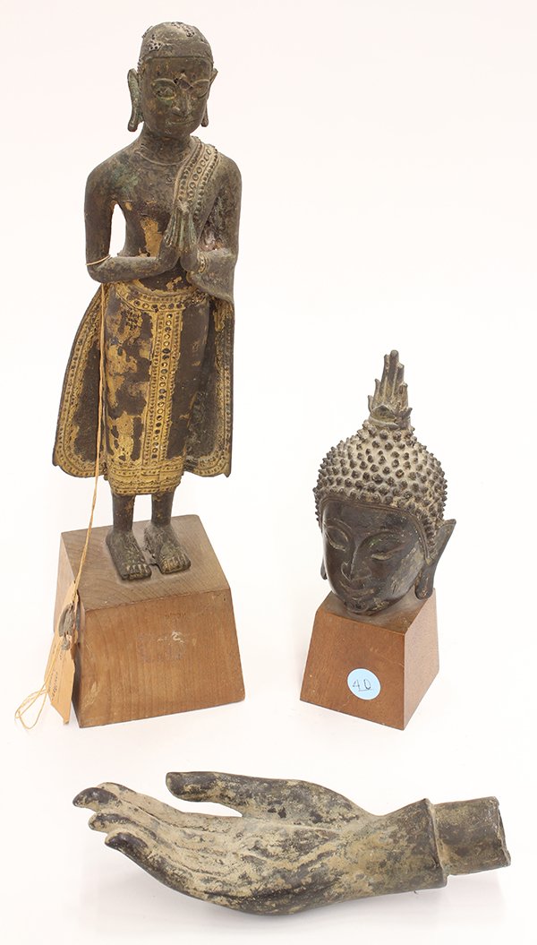 Three Thai Bronze Buddhist Figures: (lot of 3) Thai bronze Buddhist sculptures: first a head of a Buddha on a wood stand; second, a hand of a Buddhist figure with fingers outstretched; third, a gilt bronze standing monk with both hands 