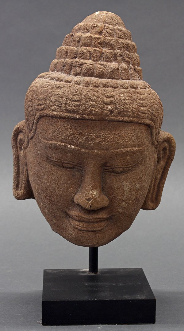 Cambodian Stone Head: Cambodian carved stone head, with a tiered chignon and a straight hairline framinig the unibrow and down cast eyes, with stand, head: 8.25"h