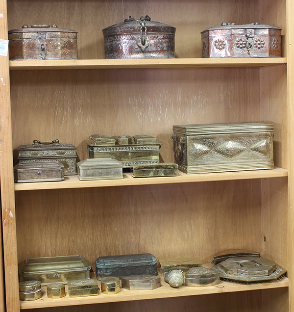 Group of Southeast Asian Betel Nut Boxes: (lot of 21) Three shelves of Southeast Asian metal betel nut boxes, a few of circular form, others with rectangular forms, largest: 6"h ×11.5"w×5"d; Provenance: From the estate of Edward Gerber