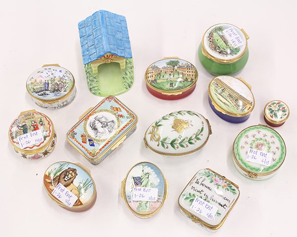 Collection of porcelain pill boxes: (lot of 13) Collection of porcelain pill boxes including several by Halcyon Days Enamels, depicting various scenes such as the Statue of Liberty; Burgis-Price View of Harvard designed by Tiffany and C