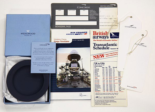 Concorde memorabilia: (Lot of over 100 items) Concorde memorabilia including (2) hallmarked British sterling port labels with Concorde insignia, a Wedgwood Concorde dish, a group of real photos, cards, in flight menus, lug