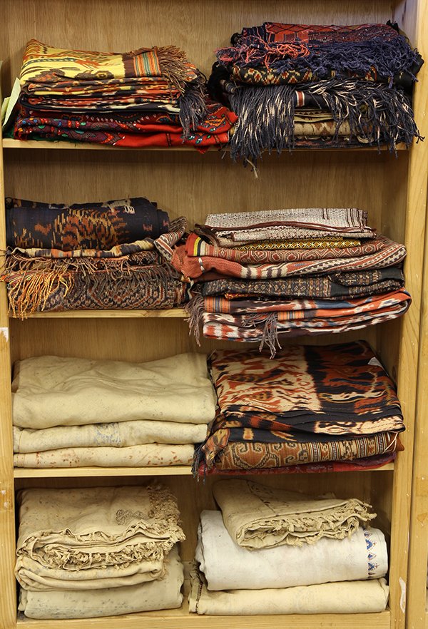 Four shelves of Indonesian textiles: (lot of 40) Four shelves of Indonesian textiles, probably from Java, Sumatra, Flores, Timor, etc., each having mutli-color abstract geometric patterns, in various sizes. Provenance: From the estate of