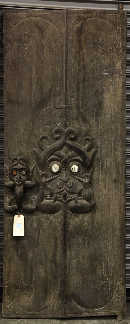 Dayak style, Indonesia carved door, second half 20th: Dayak style, Indonesia carved door, second half 20th century, the decorative heavy panel centered with pronounced abstract figures surrounded by scrolls, 78"h x 30.75"w. Provenance: From the estate of