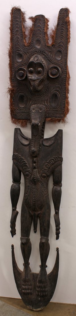 Papua New Guinea carved figural suspension hook: Papua New Guinea carved figural suspension hook, the male body depicting scarification, and surmounted by zoomorph facial features, 88"h. Provenance: From the estate of Edward Gerber