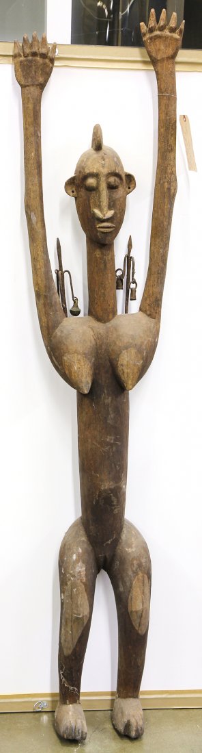 Dogon style, Mali carved wood standing female figure: Dogon style, Mali carved wood standing female figure with arms raised and iron mounts on shoulders, 68"h. Provenance: From the estate of Edward Gerber