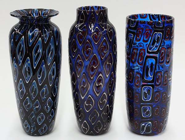 (lot of 3) Art glass vases by Michael Nourot (American: (lot of 3) Art glass vases by Michael Nourot (American b.1949), circa 1980, each vase of cylindrical form, having repeating geometric patterns executed in the Venetian murrini technique, in ruby on bl