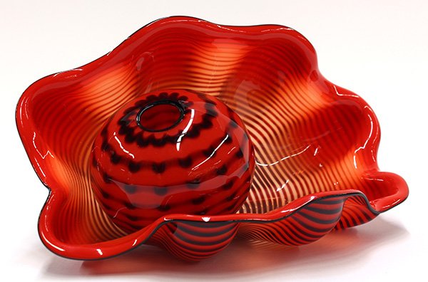 Dale Chihuly (American b: Dale Chihuly (American b. 1941) Seafoam glass group, in two parts, each having a black on crimson body with black lip, consisting of a naturalistic vessel having a shaped body, 4.5"h x 10"w, together 