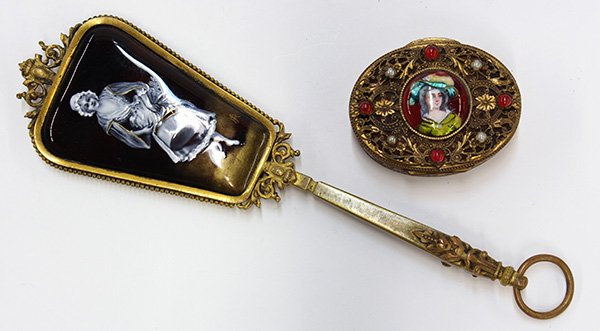 French gilt metal dresser articles: (lot of 2) French gilt metal dresser articles including a hand mirror with a central enamel reserve depicting a maiden; and a pill box with jeweled accents and a central medallion decorated with a bus