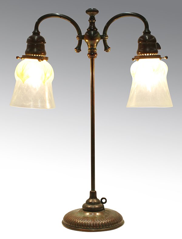 Tiffany Studios: Tiffany Studios, New York, table lamp, the two associated shades having a pulled feather design, one marked L.C.T, suspended from the patinated bronze arms conjoined at the columnar standard, and risi