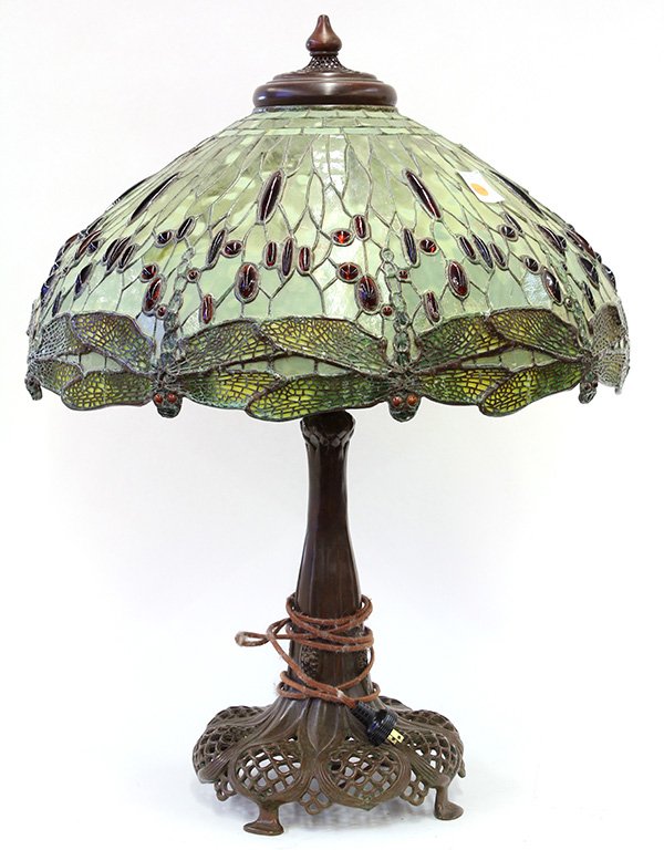Tiffany style patinated bronze leaded glass lamp: Tiffany style patinated bronze leaded glass lamp, executed by Woolsey Studios in the 'Dragonfly' pattern, the dome shade with amber jeweled accents continuing to the dragonfly border, surmounting the 