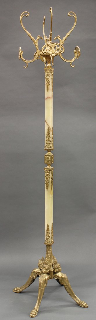 Victorian style brass and onyx coat rack, having: Victorian style brass and onyx coat rack, having reticulated scroll work arms, above the onyx standard, continuing to the tripod base having figural medallions, and rising on outswept feet, 70"h