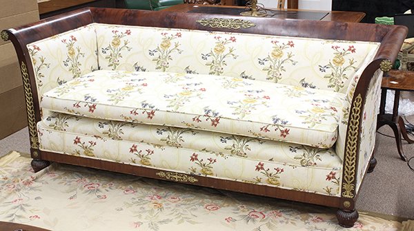 French Empire settee: French Empire settee, circa 1830, executed in flame mahogany, the sleigh form having an applied gilt scroll work mount, continuing to the even arms accented with gilt metal rosette medallions, and ris