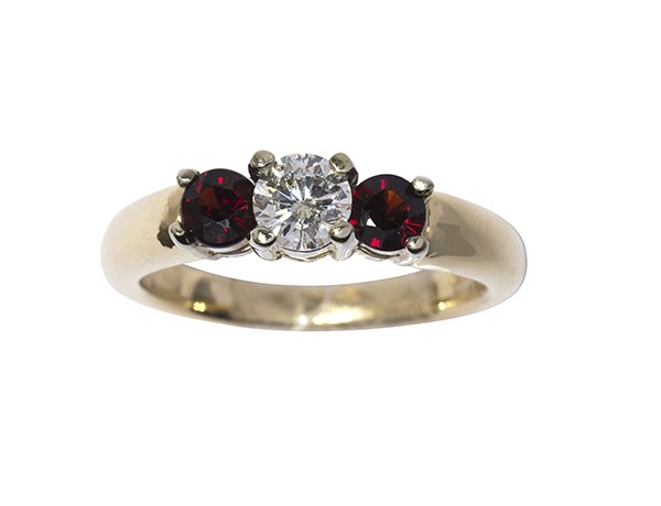 Diamond, garnet and 14k gold ring: Diamond, garnet and 14k gold ring center set with a round brilliant cut diamond weighing approximately 0.42 ct., accented by two round-cut dark red garnets measuring approximately 4 mm each, set withi