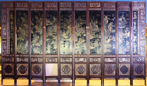 Chinese Ten Panel Lacquered Screen, Qing: Chinese lacquered ten panel wood screen, Late Qing dynasty, fronted by scenes of travellers in landscapes executed with gilt on a black lacquer ground, eight with a poetic colophon to the upper corner