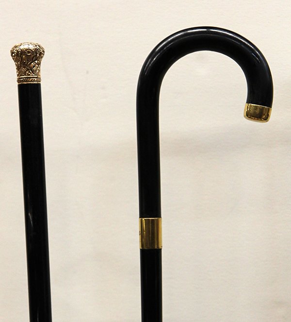 Gold cap walking sticks: (lot of 2) Gold cap walking sticks, consisting of a Tiffany & Co. crook handle stick with an 18k gold cap and collar, surmounting an ebony shaft with a horn ferrule, the collar marked 'Tiffany & Co. 1