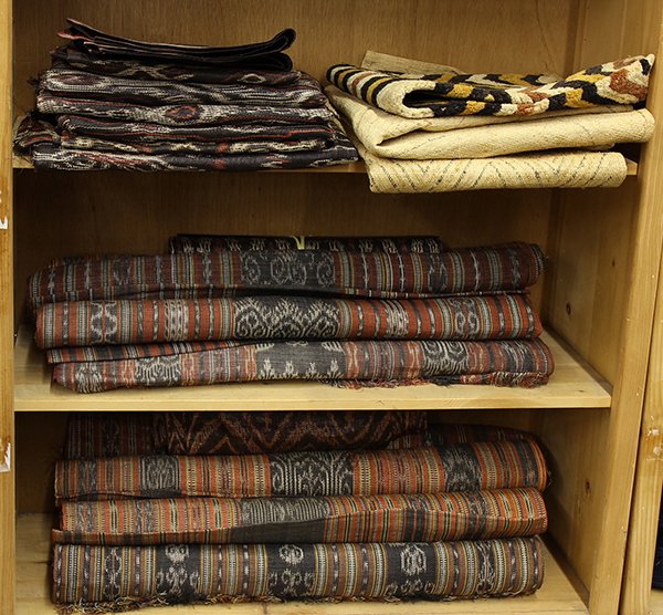 Three shelves of ethnographic textiles, including kuba: Three shelves of ethnographic textiles, including kuba cloths, and Indonesian textiles including runners and table coverings. Provenance: From the estate of Edward Gerber