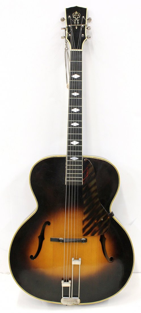 Vega C66 Acoustic Archtop Guitar circa 1936: Vega C66 Acoustic Archtop Guitar circa 1936, having a book matched spruce top, flame maple back and sides with sunburst finish, diamond form mother-of-pearl inlays, Bakelite pick guard, and hard shell