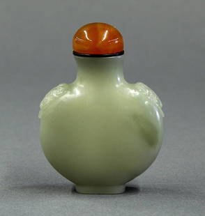 Chinese Jade Snuff Bottle with Lion Handles: Chinese jade snuff bottle, the flattened ovoid body carved with fu-lions suspending mock ring handles, raised on a rectangular foot, the sea-green matrix with a few dark patches, 2.5"h