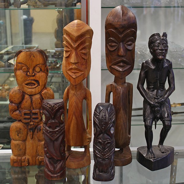 Ethnographic carved figures of Oceanic regions: (lot of 6) Ethnographic carved figures of Oceanic regions including an Indonesian male figure depicted traditionally with a kris sword, 17"h; two stylized male figures having defined geometric facial 