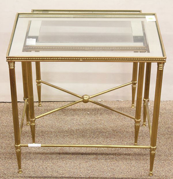 (lot of 2) Hollywood Regency nesting tables: (lot of 2) Hollywood Regency nesting tables, executed in brass and glass, having rectangular captured mirrored glass tops resting on tapered reeded legs, largest; 19.5'h x 20'l x 13.5"d