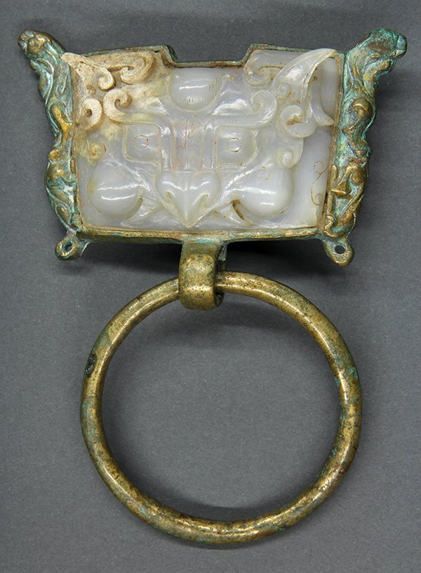 Chinese Jade/Copper Alloy Door Knocker: Chinese jade and copper alloy door knocker, featuring an archaistic zoomorph carved from a grey-white matrix, set within a mounting framed by two mythical beasts, the lower section suspends a loose ri