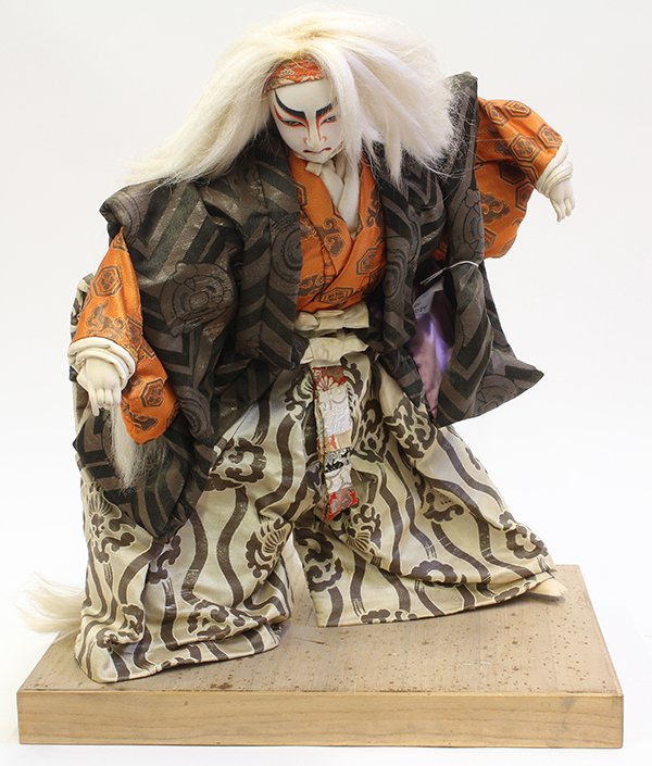 Japanese Kabuki Doll: Japanese kabuki doll in traditional attire, early/mid 20th century, a lion dance actor with white hair in hakama and orange silk kimono on wooden base, overall (with base): 20"h; Provenance: Unaccessi