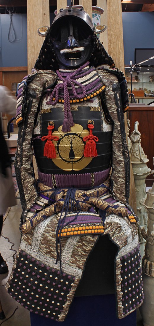 Japanese Samurai Armor Set: Japanese samurai armor set, includes iron kabuto, menpo, breast plates, shoulder plates, chain-mail sleeves with gauntlets and skirt, with mygoa crest on chest plate and kabuto, 52"l; Provenance: Unac