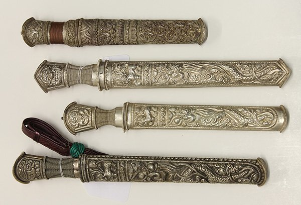 (lot of 4) Southeast Asian knife group, each having a: (lot of 4) Southeast Asian knife group, each having a repousse decorated grip and sheath, largest 16"l; Provenance: From the estate of Edward Gerber