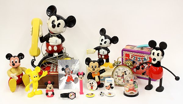 Four shelves of associated Mickey Mouse toys and: Four shelves of associated Mickey Mouse toys and ephemera, including lunch boxes, baby rattles, magnets, watches and clocks, flash light, buttons, talking toothbrushes, banks, phones, and pez dispense