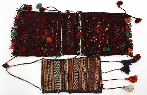 (lot of 2) South Asian textile saddle bags, consisting: (lot of 2) South Asian textile saddle bags, consisting of a kilim example and a pile carpet example, largest; 45"l x 20.5"w; Provenance: From the estate of Edward Gerber