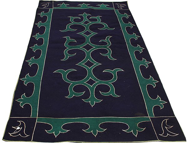 Wool felt coverlet, having green arabesque designs: Wool felt coverlet, having green arabesque designs outlined in white on a navy ground; Provenance: From the estate of Edward Gerber