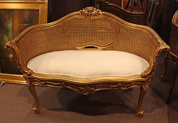 (lot of 2) Louis XV style giltwood carved settees: (lot of 2) Louis XV style giltwood carved settees, each having a carved crest surmounting the cane back, the seat rail accented with relief carved floral sprays, and rising on cabriole legs, 33.5"h x