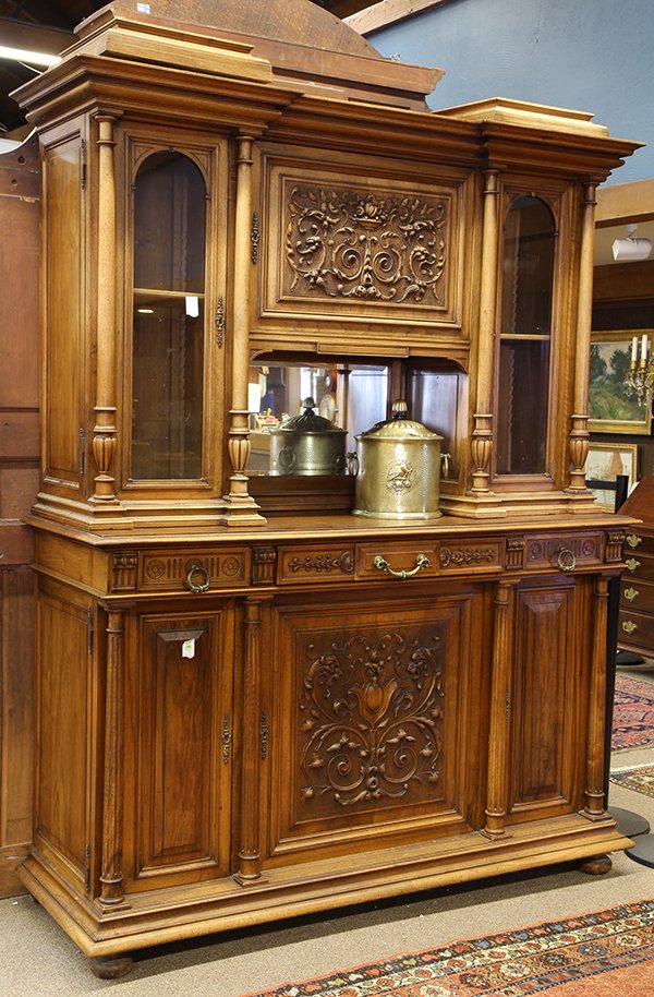 Henri II style carved oak buffet: Henri II style carved oak buffet, circa 1890, the three door superstructure centering a panel with a carved urn and flourishes, above a niche with a beveled mirror, flanked by glazed compartments fron