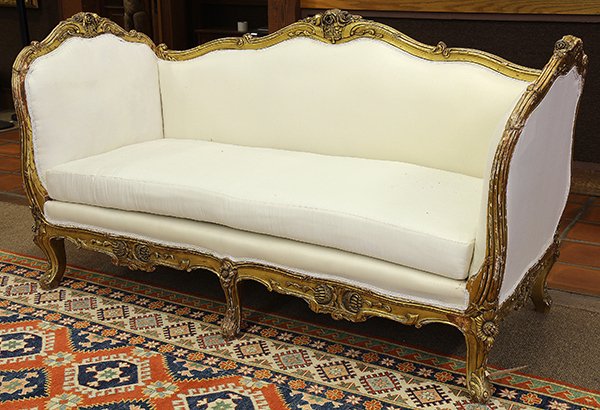 Rococo style giltwood carved daybed: Rococo style giltwood carved daybed, having a graduated crestrail centered with rose carved medallions surmounting the padded back, and rising on cabriole legs, 41"h x 80"w x 33"d