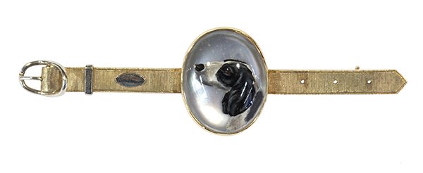 Reverse crystal intaglio and 14k yellow gold brooch: Reverse crystal intaglio and 14k yellow gold brooch centering one reverse crystal intaglio depicting a hunting dog set in a 14k yellow and white gold belt motif mounting, 1920's, length 2 3/8", weighs