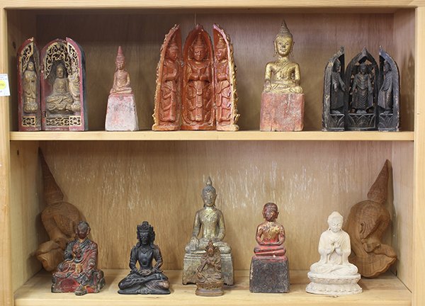 Two Shelves of Southeast Asian Buddhist Wood Carvings: (lot of 13) Two shelves of mostly Southeast Asian Buddhist wood carved statues, including three wooden triptychs, largest: 13.5"h. Provenance: From the estate of Edward Gerber